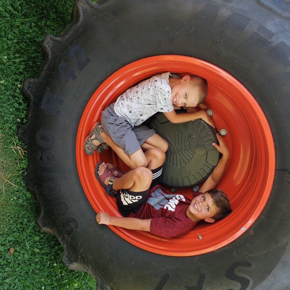 Cousins Jackson Darlage and Charlie Bennett checking out a big tractor tire.