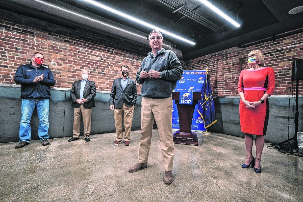 Gov. Eric Holcomb, second from right, is flanked on his left by his campaign manager Kyle Hupfner, Rep. Greg Pence, Sen. Todd Young and Lt. Gov. Suzanne Crouch on his right, as he addresses supporters during a campaign event at the Upland Columbus Pump House in Columbus, Ind., Monday, Nov. 2, 2020. Gov. Eric Holcomb and Lt. Gov. Crouch visited with a group of supporters at the restaurant on their last campaign stop before election day. Mike Wolanin | The Republic