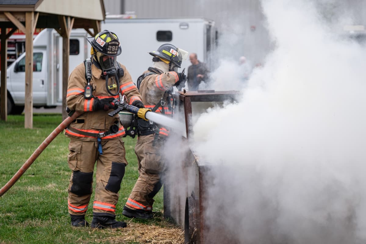 Columbus firefighters Casey Taylor, left, and Andy Johns demonstrate how they put out a car fire during the opening of the new Evolution Training Center in Columbus, Ind., Tuesday, Oct. 29, 2019. Mike Wolanin | The Republic