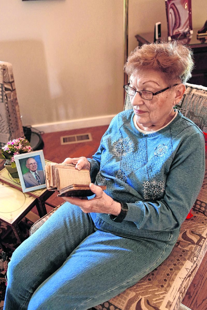 Henrietta Snively, photo of Smith Frederick Snively beside her, reads the Snively family Bible that was published in Scotland in 1793, at her home, Wednesday, March 31 ,2021 Carla Clark | For The Republic
