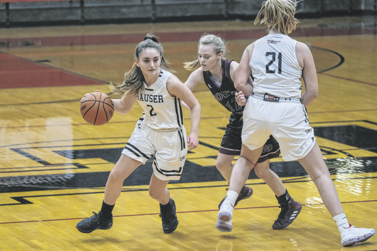 Hauser’s Kyliegh Parrott, left, dribbles up the court as teammate Hannah Johnson, right, sets a screen on South Decatur’s Mary Gasper, center, during a girls basketball tournament at Edinburgh Community High School in Edinburgh, Ind., Monday, Dec. 21, 2020. Mike Wolanin | The Republic