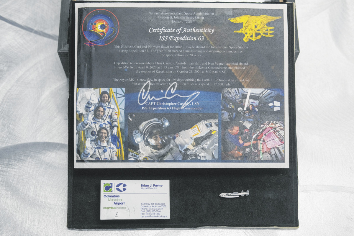 A view of the certificate of authenticity showing that Columbus Municipal Airport Director Brian Payne’s business card and C-119 pin orbited the Earth on the International Space Station on display his airport office in Columbus, Ind., Monday, April 26, 2021. His pin and business card were taken into orbit by Astronaut Chris Cassidy. A friend of his whose aunt is married to Cassidy arranged for the items to be taken into orbit. Mike Wolanin | The Republic