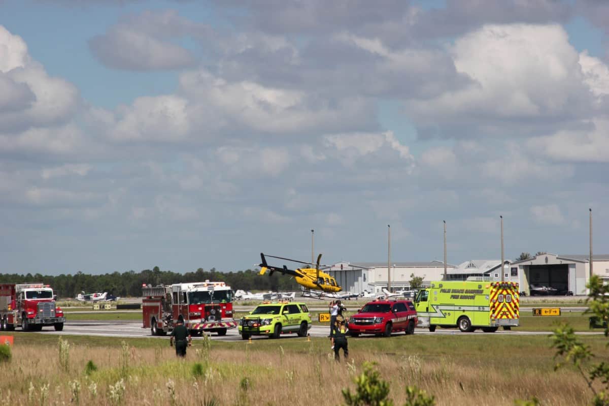 Palm Beach County and Palm Beach Gardens Fire Rescue vehicles stand by following a plane crash near Palm Beach Gardens, Fla., on Thursday, Oct. 8, 2020. All seven people on board sustained injuries along with two people who tried to rescue those aboard. Photo courtesy of the Palm Beach Post.