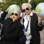 White shirts. Black ties. Bald caps. Pitbull’s fans party like clones worldwide